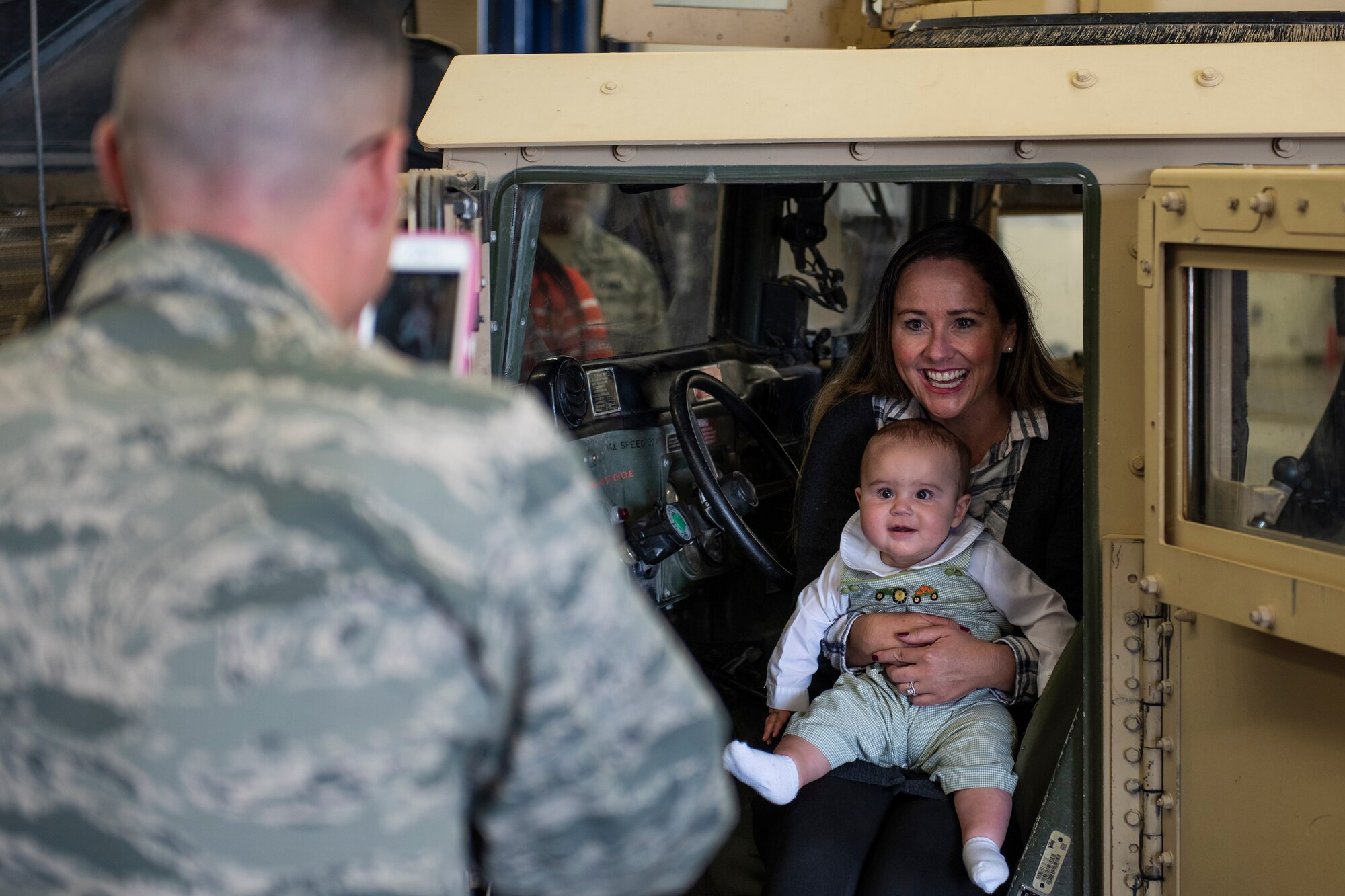 U.S. Air Force Maj. Daniel McGuire, 377th Logistics Readiness Squadron commander, takes a photo of his wife, Nicole and his son, Judah, in a Humvee during a spouse immersion event for the LRS vehicle management flight at Kirtland Air Force Base, N.M., and Oct. 30. Key spouses participated in the spouse immersion event to familiarize themselves with the vehicle management flight and provide them with an overview of their mission and resources that support Team Kirtland. Spouses and children were able to explore the different vehicles that the flight manages and maintains. (U.S. Air Force photo by Airman 1st Class Austin J. Prisbrey)