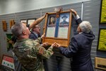 Maj. Gen. James Hoyer, Adjutant General of the West Virginia National Guard assists brothers Phillip and Claude Gaujot  in hanging a dedication plaque in honor of their great uncles Antoine and Julien Gaujot, Nov. 1, 2018, at the Logan/Mingo Readiness Center in Omar, West Virginia. The West Virginia National Guard armory was dedicated in honor of the brothers , both Congressional Medal of Honor recipients and former Soldiers who served in the late 1800's and early 1900's. (West Virginia National Guard photo by Bo Wriston)