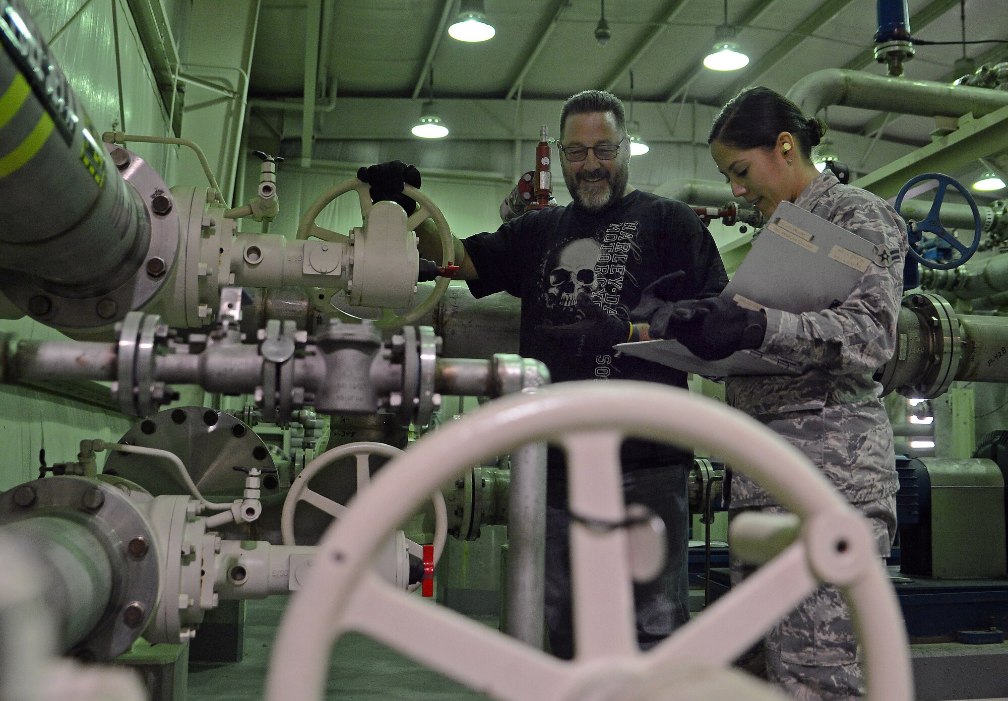 Airman 1st Class Kelsey Villegas, 627th Logistics Readiness Squadron fuels apprentice, and Gary Lam, 627th LRS fuels supervisor, inspects one of many fuel valves Oct. 19, 2018 at Joint Base Lewis-McChord, Wash.