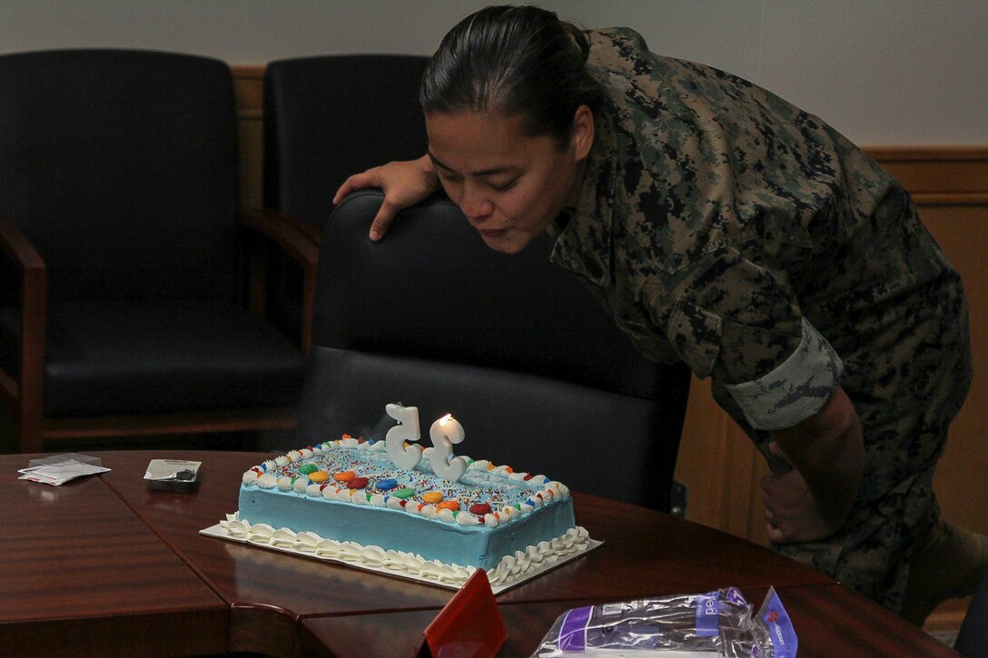 Gunnery Sgt. Tiffany A. Freeman, U.S. Marine Corps Forces Korea personnel chief, blows out candles during the command’s celebration of her birthday, here.  The Marines of MARFORK G-1 surprised Freeman with the birthday cake and the recognition of the entire staff. (Official U.S. Marine Corps photo by Capt. John Parry/ Released)