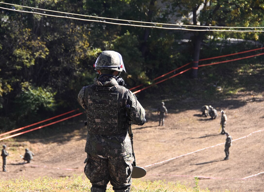 Tom Meeks (far right), a United States  Army Corps of Engineers, Engineering and Support Center quality control representative, surveys an area near the South Korea Demilitarized Zone along with Republic of Korea
Army engineer soldiers during a mine clearing mission, Oct. 19.