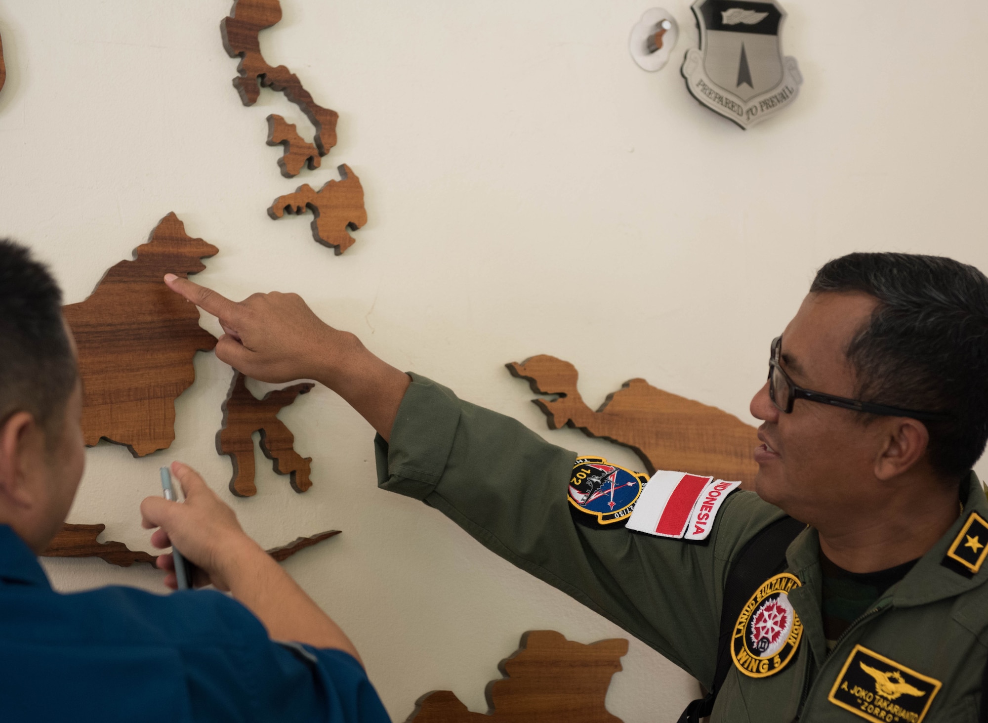 Indonesian air force Air First Marshal Alfonsius Takarianto points to his town on a giant map at Headquarters Pacific Air Forces (PACAF) after a briefing during a tour of Joint Base Pearl Harbor-Hickam, Hawaii, Oct. 23, 2018.