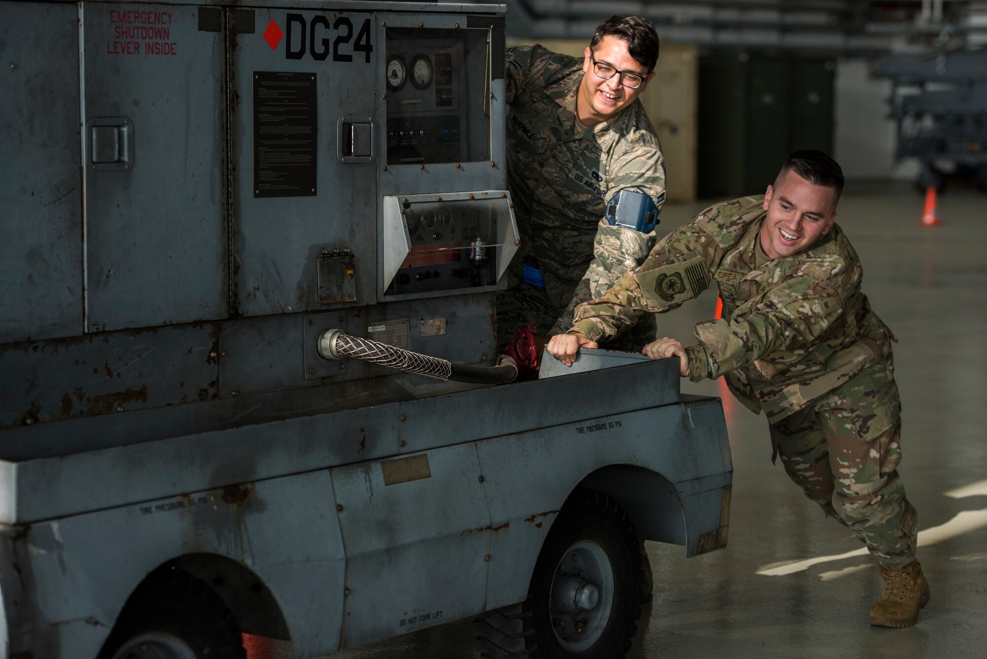 U.S. Air Force 721st Air Mobility Operations Group airmen push an auxiliary power unit as part of the maintenance relay during the 721st AMOG safety down day on Ramstein Air Base, German, Oct. 19, 2018. In addition to the relay, physical fitness, resilience and other wingman concepts were all included in the safety down day. (U.S. Air Force photo by Senior Airman Devin M. Rumbaugh)