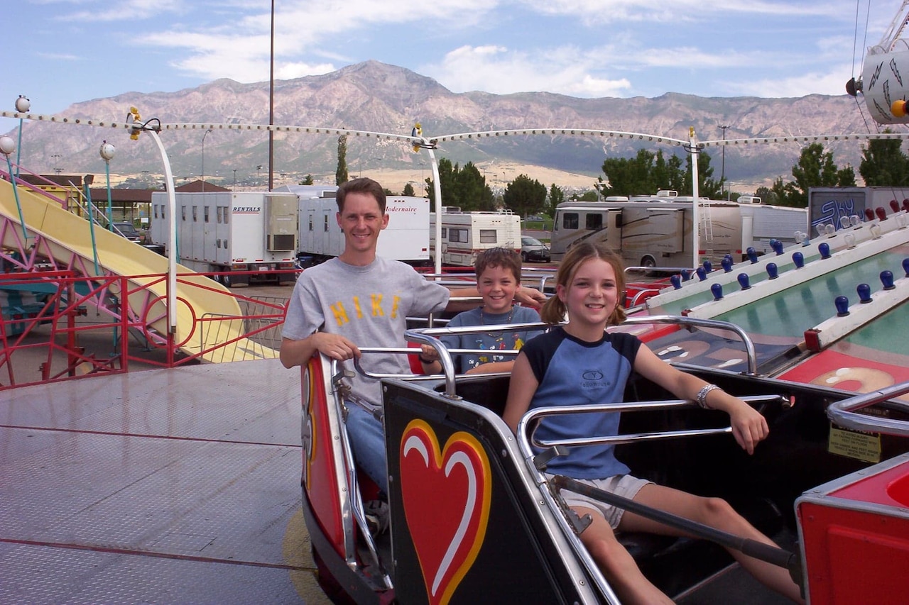 Three people enjoy an amusement park ride.
