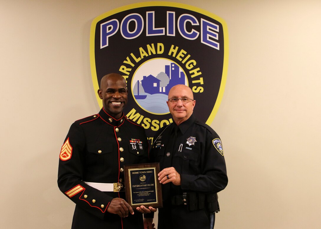 The City of Maryland Heights presents the city’s Hometown Hero Award to Staff Sgt. Marc Cox, at its city council meeting in Maryland Heights, Missouri, November 1, 2018. Cox, a canvassing recruiter with Marine Corps Recruiting Station St. Louis, received the recognition for his life-saving efforts when he assisted the Maryland Heights Police Department preventing a young woman from jumping off an overpass on Interstate 270 on May 4, 2018.