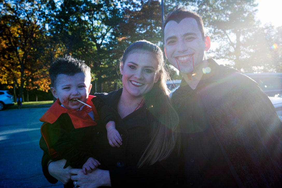U.S. Air Force Capt. Manuel Medina, a KC-135 pilot with the 64th Air Refueling Squadron, poses with his wife and son during the Airmen and Family Readiness Trunk-or-Treat event Oct. 26, 2018, at Pease Air National Guard Base, N.H. More than 20 service members and their families decorated their car trunks with games, candy and other treats for everyone to enjoy. (Photo by Airman 1st Class Victoria Nelson, 157th ARW Public Affairs)
