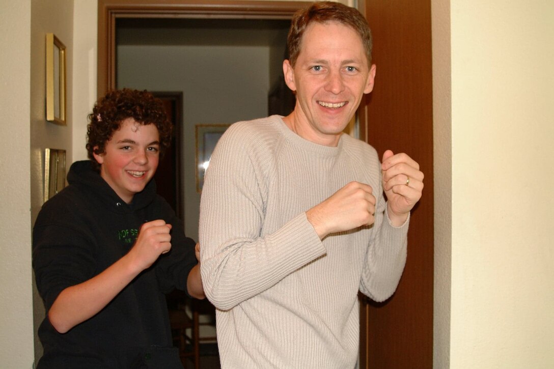 Two men pose for a picture with clenched fists.