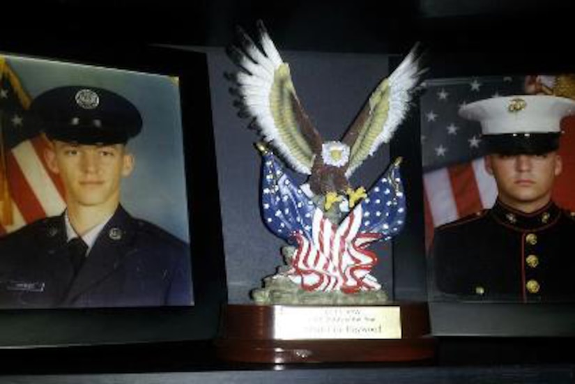 Two framed pictures of men in military uniforms sit on a table.