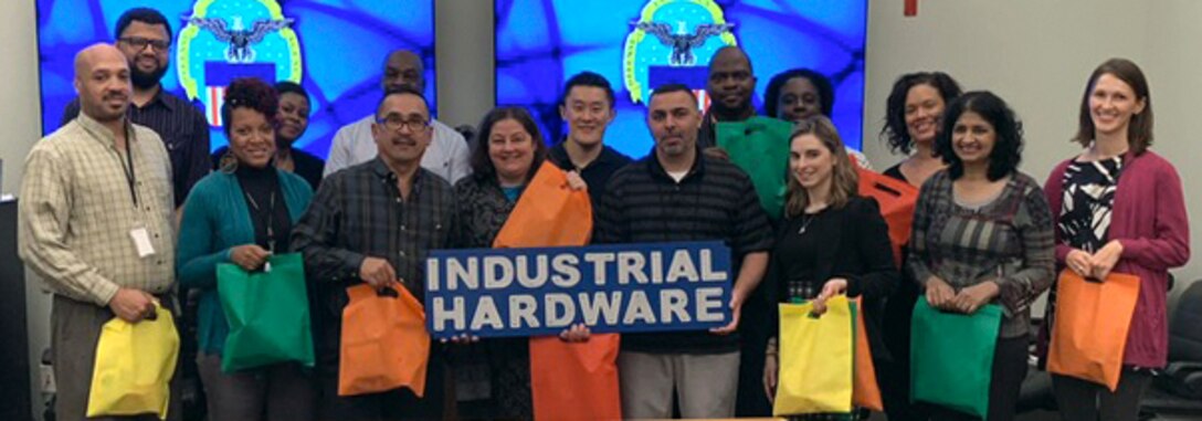 Participants in the DLA Troop Support Industrial Hardware Success and Partnership in Reaching Excellence mentoring pose with activity bags stuffed after a meeting Nov. 1, 2018, in Philadelphia.