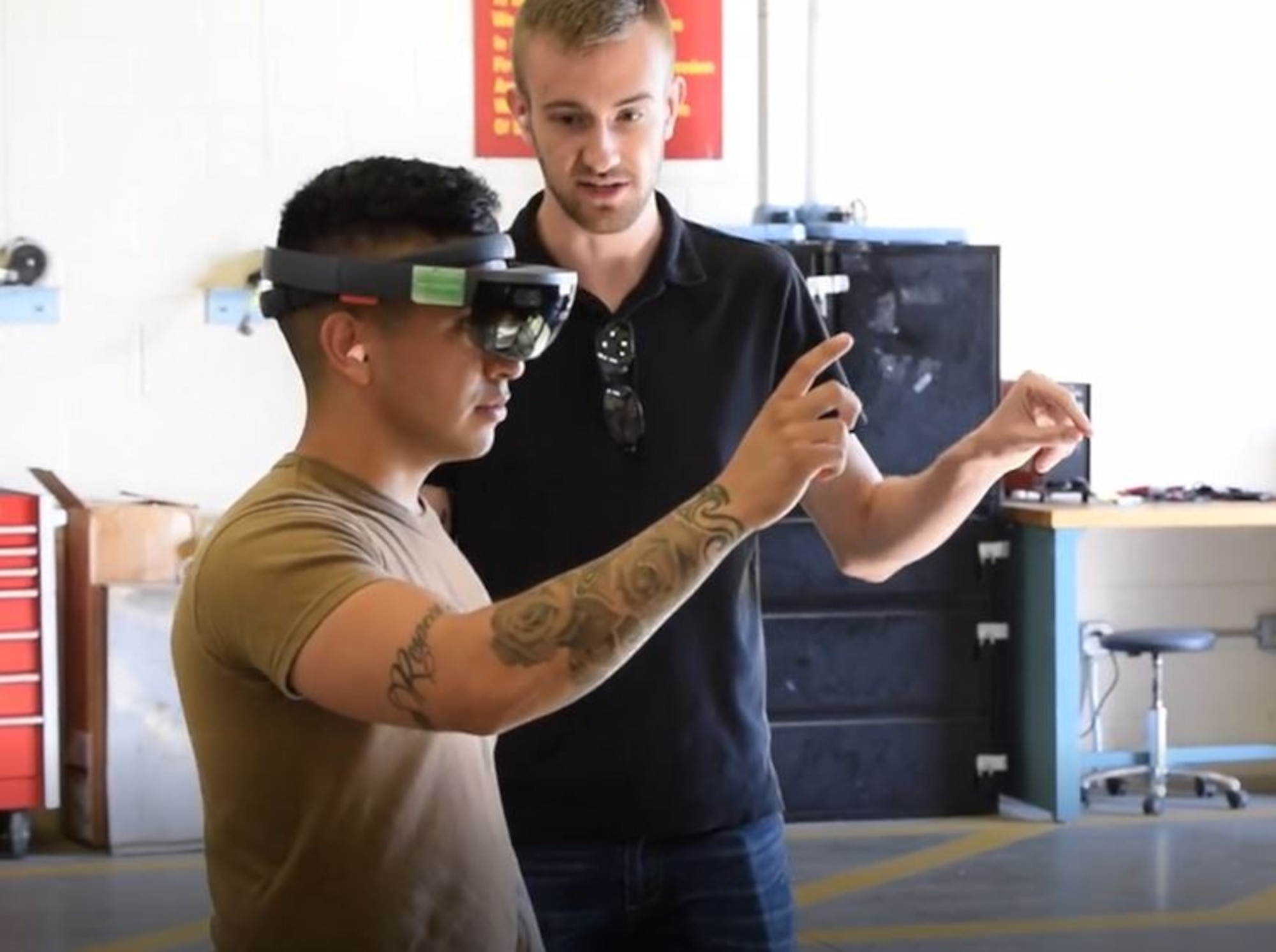 Team Collaborative Augmented Reality Maintenance Assistant (CARMA) lead Connor Hagerty shows a Joint Base McGuire-Dix-Lakehurst, N.J. Airmen how to use CARMA. (U.S. Navy photo)