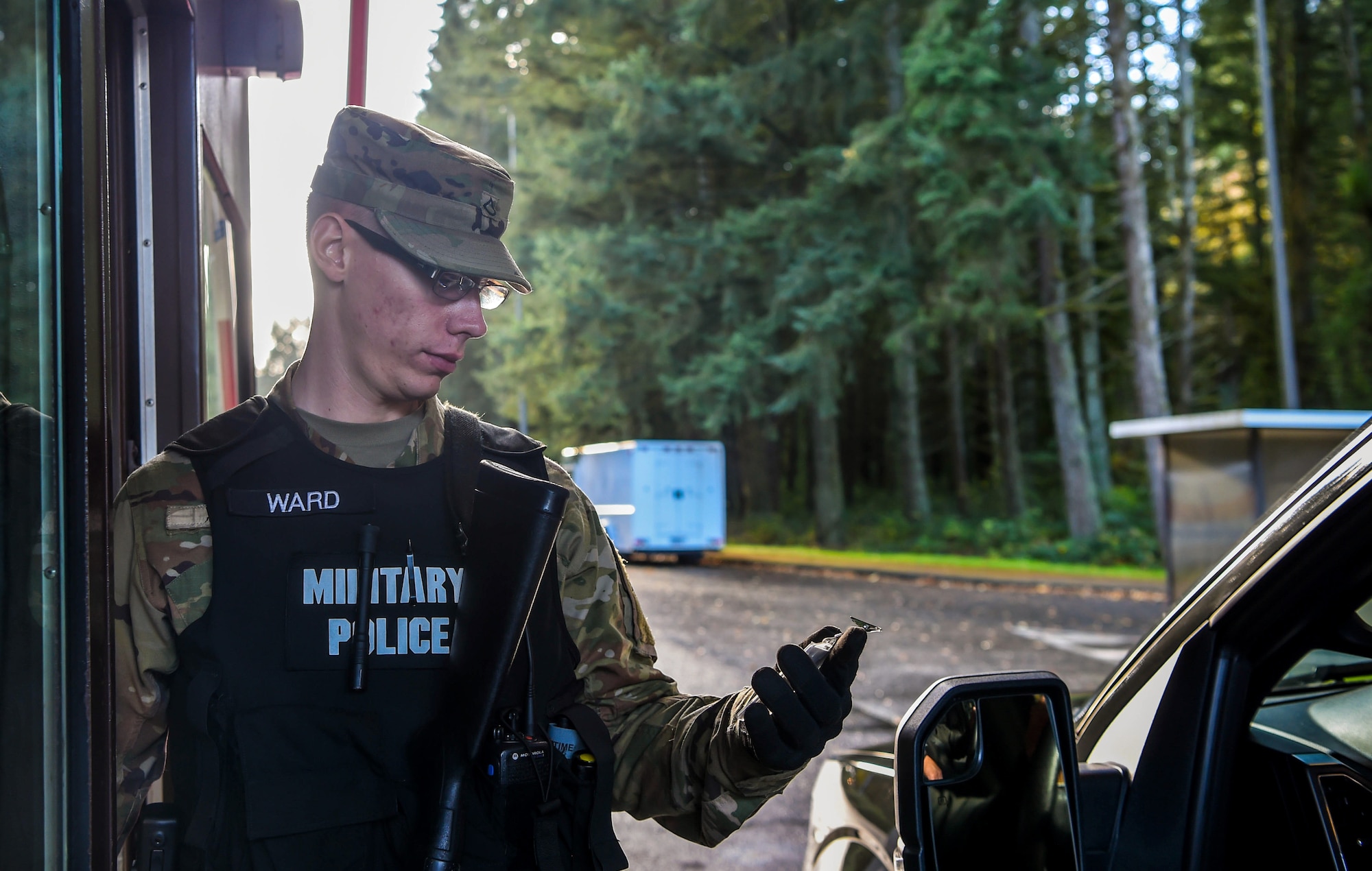 U.S. Army Private First Class James Ward, 170th Military Police Company military police, verifies access credentials at the McChord Field main gate, Joint Base Lewis-McChord (JBLM), Wash., Nov. 2, 2018. Overseeing operational control of the day-to-day law enforcement mission and access control is part of the provost marshal duties. U.S. Air Force Maj. Michael Holt, 627th Security Forces Squadron commander, recently became JBLM deputy provost marshal. (U.S. Air Force photo by Senior Airman Tryphena Mayhugh)
