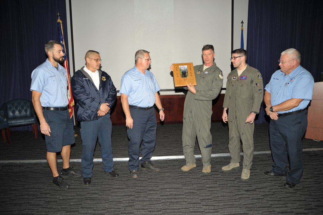 Lt. Col. Lee Glenn and 1st Lt. Nick Donato present a custom plaque to members of the 12th OSS’ egress shop