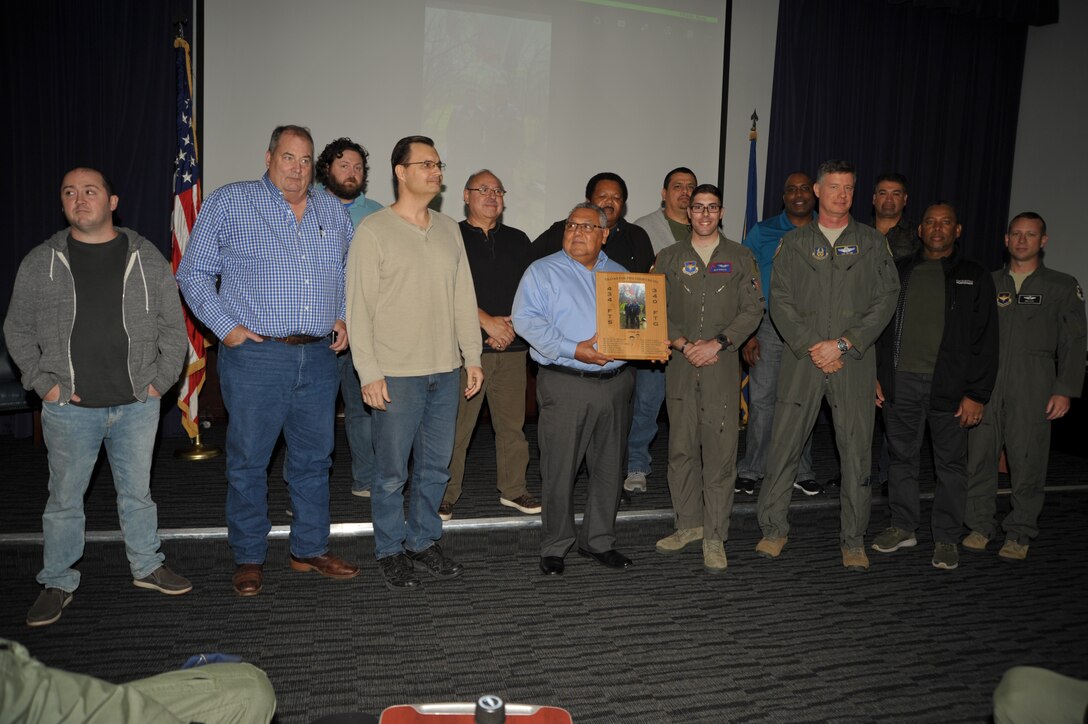 Lt. Col. Lee Glenn and 1st Lt. Nick Donato present a custom plaque to members of the 12th OSS’ aircrew flight equipment shop