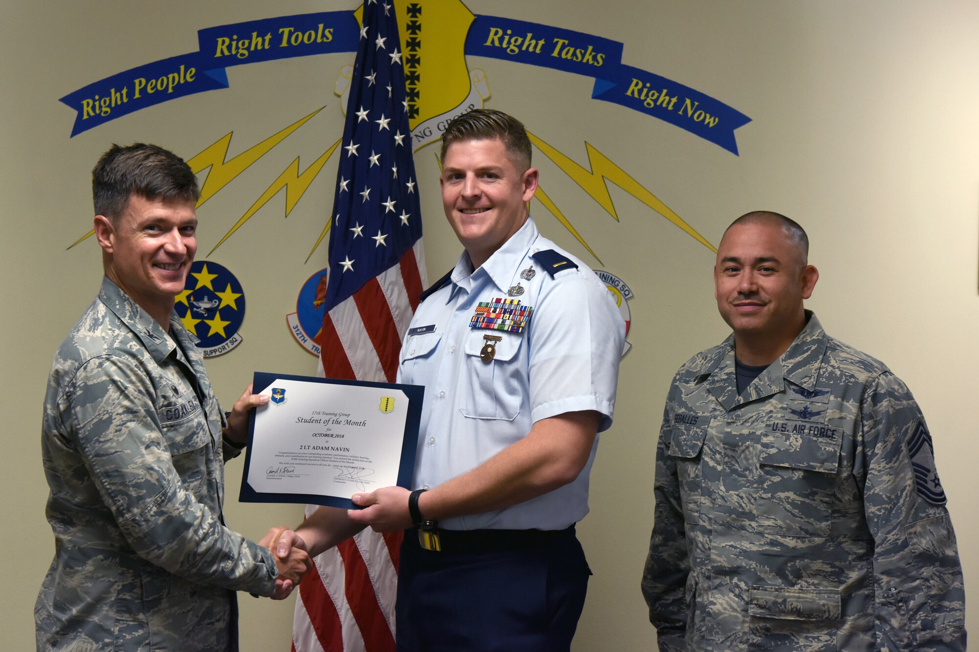 U.S. Air Force Col. Thomas Coakley, 17th Training Group commander, presents the 315th Training Squadron Officer Student of the Month award to 2nd Lt. Adam Navin, 315th TRS student, at Brandenburg Hall on Goodfellow Air Force Base, Texas, Nov. 2, 2018. The 315th TRS’s vision is to develop combat-ready intelligence, surveillance and reconnaissance professionals and promote an innovative squadron culture and identity unmatched across the U.S. Air Force. (U.S. Air Force photo by Airman 1st Class Zachary Chapman/Released)