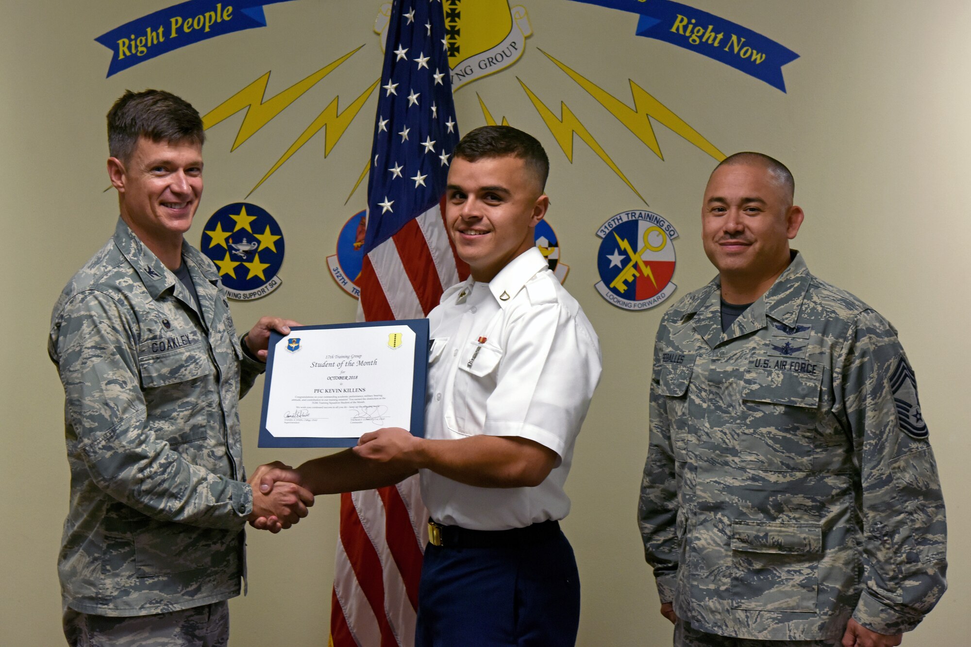 U.S. Air Force Col. Thomas Coakley, 17th Training Group commander, presents the 312th Training Squadron Student of the Month award to Pfc. Kevin Killens, 312th TRS student, at Brandenburg Hall on Goodfellow Air Force Base, Texas, Nov. 2, 2018. The 312th TRS’s mission is to provide Department of Defense and international customers with mission ready fire protection and special instruments graduates and provide mission support for the Air Force Technical Applications Center. (U.S. Air Force photo by Airman 1st Class Zachary Chapman/Released)