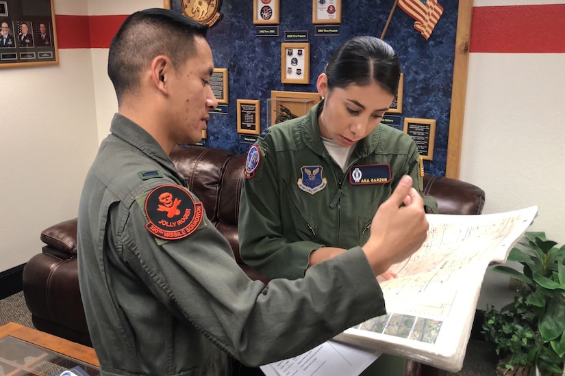 Two Air Force missileers look over a map.