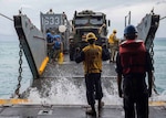 OKINAWA, Japan (Oct. 29, 2018) Boatswain’s Mate 3rd Class Nayyaamunhotep Stubbs signals the Landing Craft, Utility (LCU) 1633 to approach the well deck of the amphibious dock landing ship USS Ashland (LSD 48) to receive equipment in preparation to conduct Defense Support to Civil Authorities (DSCA) efforts. Sailors and Marines from Ashland, part of the Wasp Amphibious Ready Group and 31st Marine Expeditionary Unit team, are preparing to provide Department of Defense support to the Commonwealth of the Northern Mariana Islands’ civil and local officials as part of the FEMA-supported Typhoon Yutu recovery efforts.