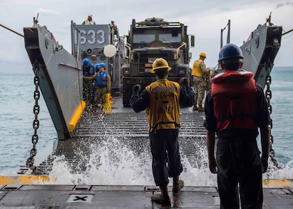 OKINAWA, Japan (Oct. 29, 2018) Boatswain’s Mate 3rd Class Nayyaamunhotep Stubbs signals the Landing Craft, Utility (LCU) 1633 to approach the well deck of the amphibious dock landing ship USS Ashland (LSD 48) to receive equipment in preparation to conduct Defense Support to Civil Authorities (DSCA) efforts. Sailors and Marines from Ashland, part of the Wasp Amphibious Ready Group and 31st Marine Expeditionary Unit team, are preparing to provide Department of Defense support to the Commonwealth of the Northern Mariana Islands’ civil and local officials as part of the FEMA-supported Typhoon Yutu recovery efforts.