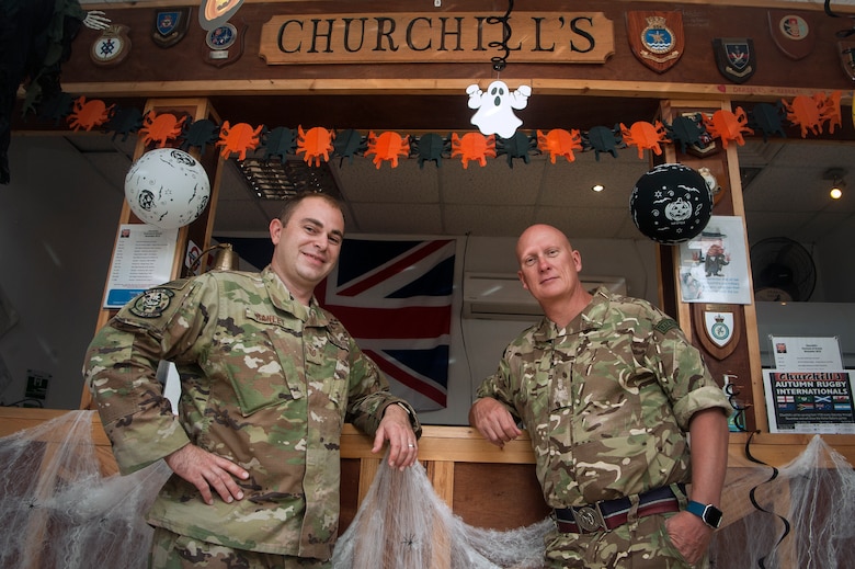 U.S. Air Force Tech. Sgt. Dave Ranlet, left, 379th Expeditionary Logistics Readiness Squadron commander support staff resource advisor and security manager, and Royal Air Force Warrant Officer Chris Mears, right, 83rd Expeditionary Air Group group warrant officer, showcase Churchill’s Club renovations Nov. 1, 2018, at Al Udeid Air Base, Qatar. Ranlet volunteered his after-duty time to help RAF forces remodel the club, applying his wood working skills in the revitalization project. The multinational team completed renovations Oct. 6, 2018. (U.S. Air Force photo by Tech. Sgt. Christopher Hubenthal)