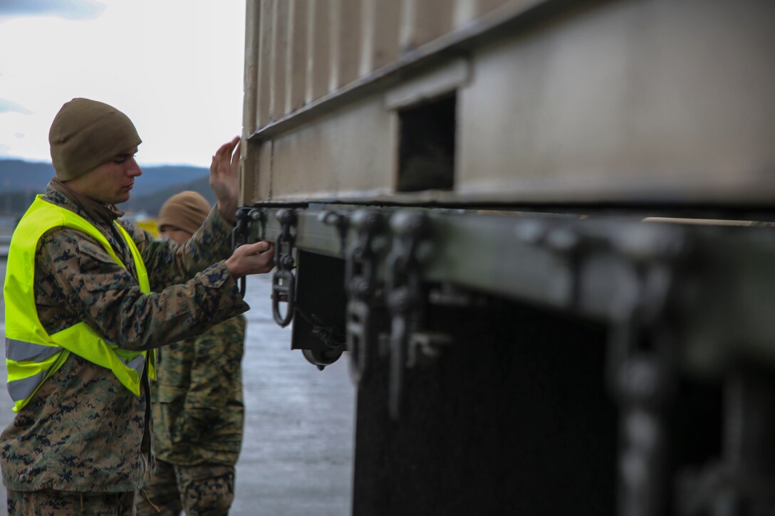 U.S. Marine Lance Cpl. Aaron Slusarczyk, a maintenance mechanic with II Marine Support Battalion, II Marine Information Group, unlocks the hooks on a 7-ton medium tactical vehicle replacement during a convoy operation for Exercise Trident Juncture. Trident Juncture 18 demonstrates II Marine Expeditionary Force’s ability to deploy, employ, and redeploy the Marine Air Ground Task Force while improving interoperability with NATO allies and partners. (U.S. Marine Corps photo by Cpl. Patrick Osino)