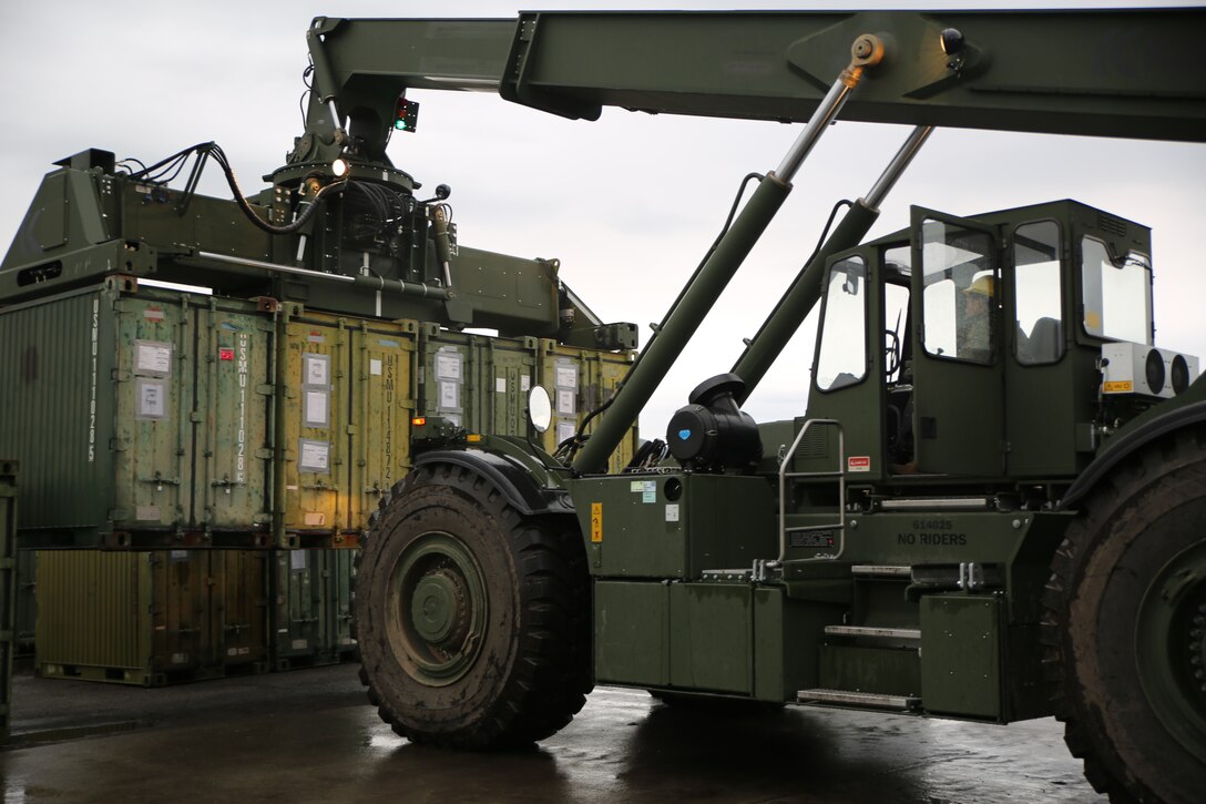 A U.S. Marine with II Marine Support Battalion, II Marine Information Group, offloads containers with supplies to be used for Exercise Trident Juncture 18 in Vaernes, Norway, Nov. 2, 2018. Trident Juncture 18 demonstrates II Marine Expeditionary Force’s ability to deploy, employ, and redeploy the Marine Air Ground Task Force while improving interoperability with NATO allies and partners. (U.S. Marine Corps photo by Cpl. Patrick Osino)