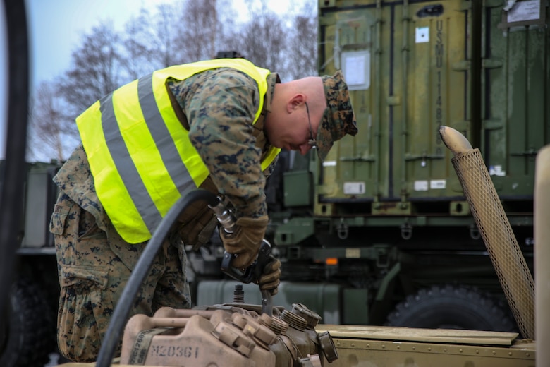 A U.S. Marine with II Marine Support Battalion, II Marine Information Group, refills fuel containers during a convoy operation for Exercise Trident Juncture. Trident Juncture 18 demonstrates II Marine Expeditionary Force’s ability to deploy, employ, and redeploy the Marine Air Ground Task Force while improving interoperability with NATO allies and partners. (U.S. Marine Corps photo by Cpl. Patrick Osino)