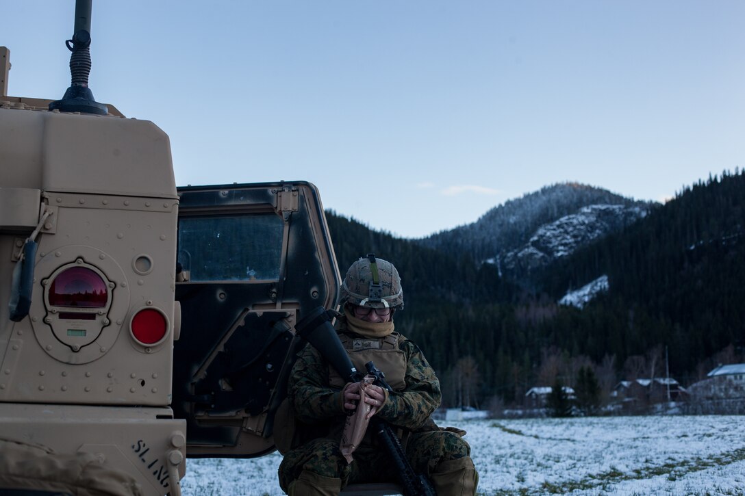 U.S Marine Corps Lance Cpl. William Evans with Bridge Company, 8th Engineer Support Battalion, 2nd Marine Logistics Group-Forward, opens a meal ready to eat beside a Humvee during Exercise Trident Juncture 18 near Voll, Norway, Oct. 29, 2018. The bridge construction enables ground units to complete a gap crossing during the exercise, which is one of the general engineering tasks 2nd MLG provides to the Marine Air-Ground Task Force. Trident Juncture 18 enhances the U.S. and NATO Allies’ and partners’ abilities to work together collectively to conduct military operations under challenging conditions. (U.S. Marine Corps photo by Lance Cpl. Scott R. Jenkins)