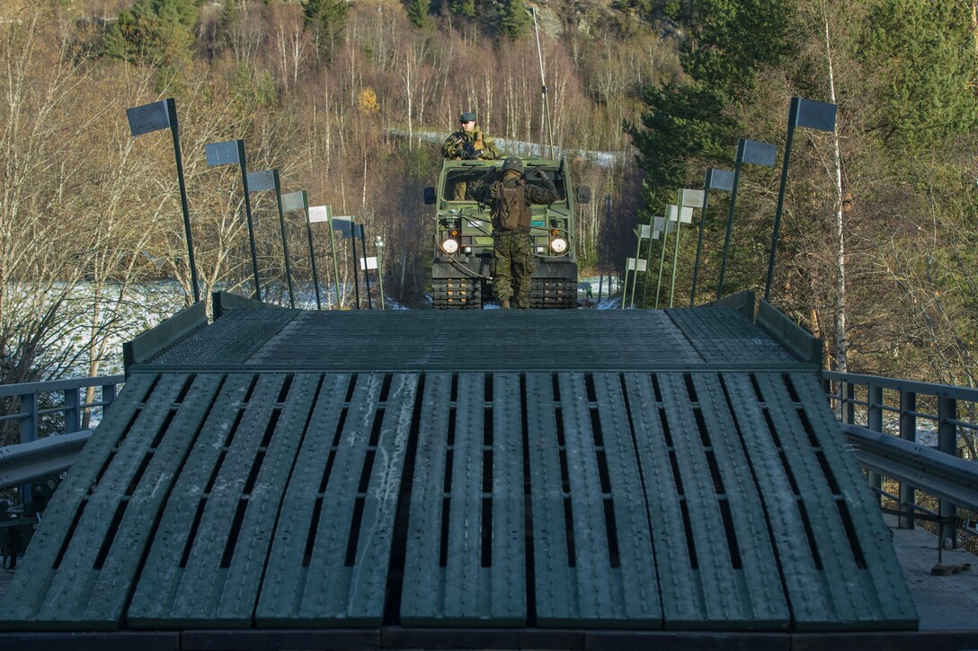 Norwegian military members use a Bandvagn-206 to cross a medium girder bridge as part of Exercise Trident Juncture 18 near Voll, Norway, Oct. 30, 2018. The bridge construction enables ground units to complete a gap crossing during the exercise, which is one of the general engineering tasks 2nd Marine Logistics Group provides to the Marine Air-Ground Task Force. Trident Juncture 18 enhances the U.S. and NATO Allies’ and partners’ abilities to work together collectively to conduct military operations under challenging conditions. (U.S. Marine Corps photo by Lance Cpl. Scott R. Jenkins)