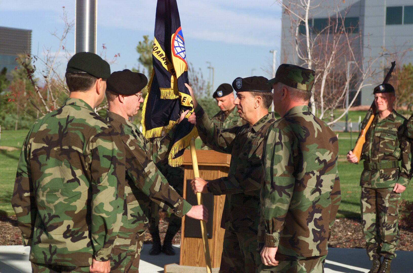 U.S. Army Col. Gary Baumann, left, the first commander of the 100th Missile Defense Brigade, accepts the brigade's flag from U.S. Army Lt. Gen. Joseph M. Cosumano, Jr., commanding general, U.S. Army Space and Missile Defense Command, during the activation ceremony of the 100th MDB Oct. 16, 2003, at Peterson Air Force Base, Colorado. The MDB is manned both by Colorado Army National Guard and active-component soldiers.