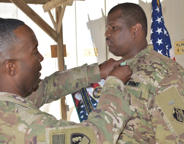 Sgt. 1st Class Derrick Wade receives the Army Commendation Medal from Afghanistan District Commander, Col. Jason Kelly at his end of tour Awards Ceremony.