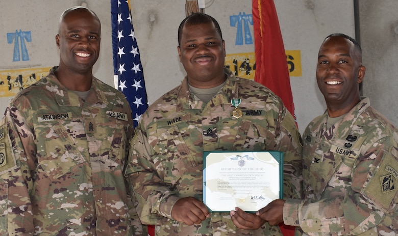 Sgt. 1st Class Derrick Wade is presented with his Army Commendation Certificate from Col. Jason Kelly, Afghanistan District Commander and Command Sergeant Major, Nathaniel Atkinson.