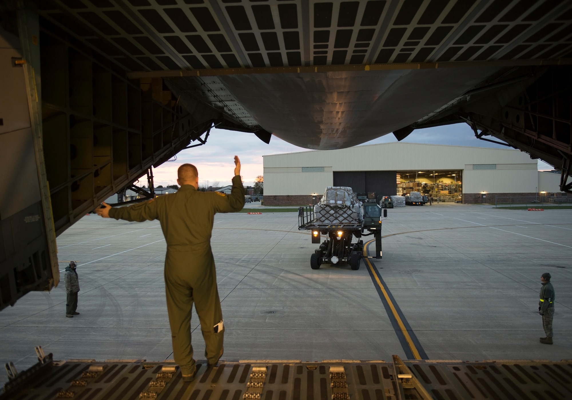 A loadmaster from the 337th Airlift Squadron directs an oncoming vehicle for loading cargo onto a C-5 Galaxy Nov. 2, 2018 at Grissom Air Reserve Base, Indiana. The 84,700 pounds of cargo contained nearly 500,000 meals that are headed for Afghanistan. (U.S. Air Force photo/Tech. Sgt. Jami K. Lancette)