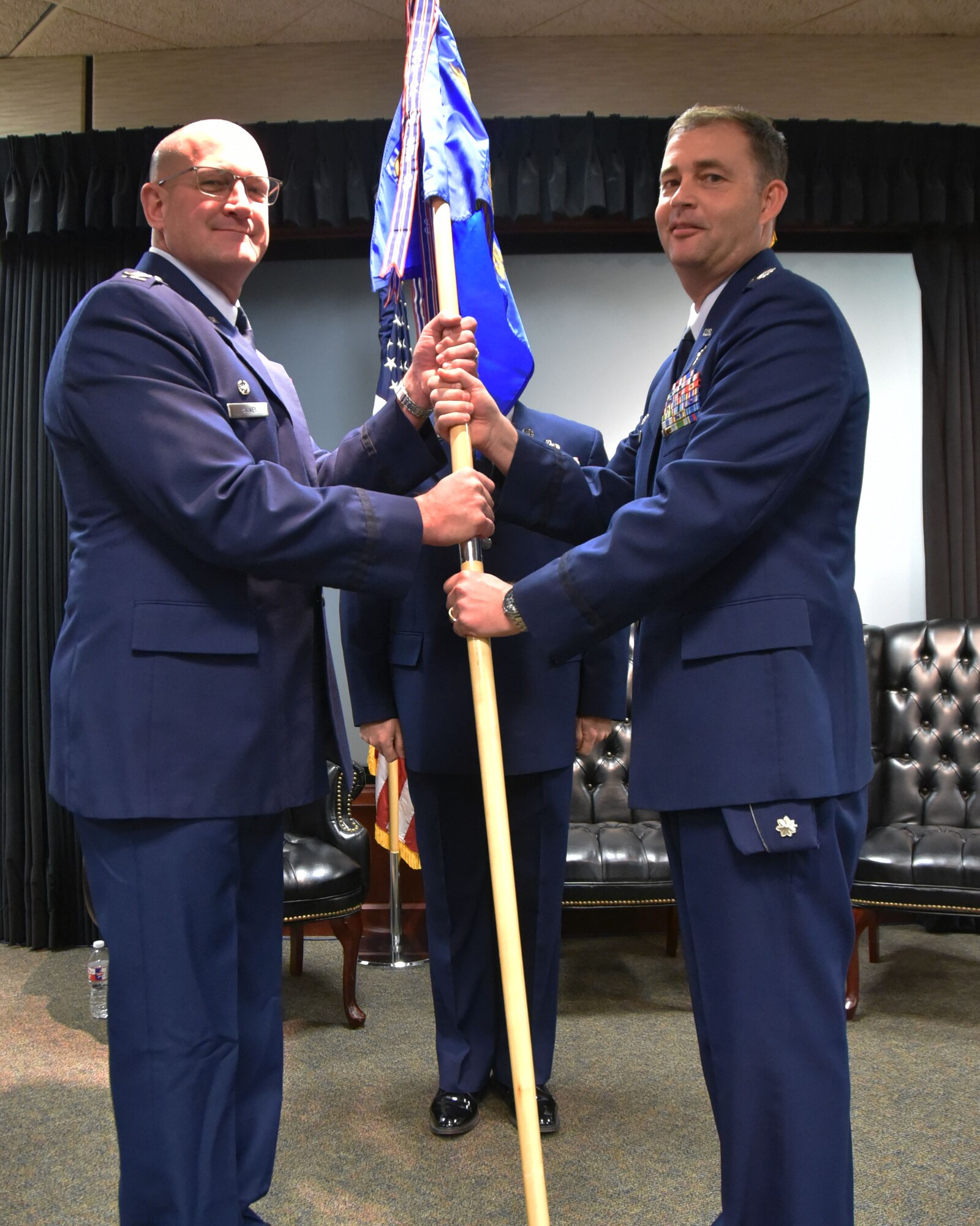 (Right to left) Lt. Col. Stacy Moore, outgoing 931st Operations Support Squadron commander, passes the guidon to Col. Kevin Rainey, 931st Operations Group commander, during a change of command ceremony Nov. 4, 2018, McConnell Air Force Base, Kan.  Moore assumed command of the 931 OSS last February.  (U.S. Air Force photo by Tech. Sgt. Abigail Klein)