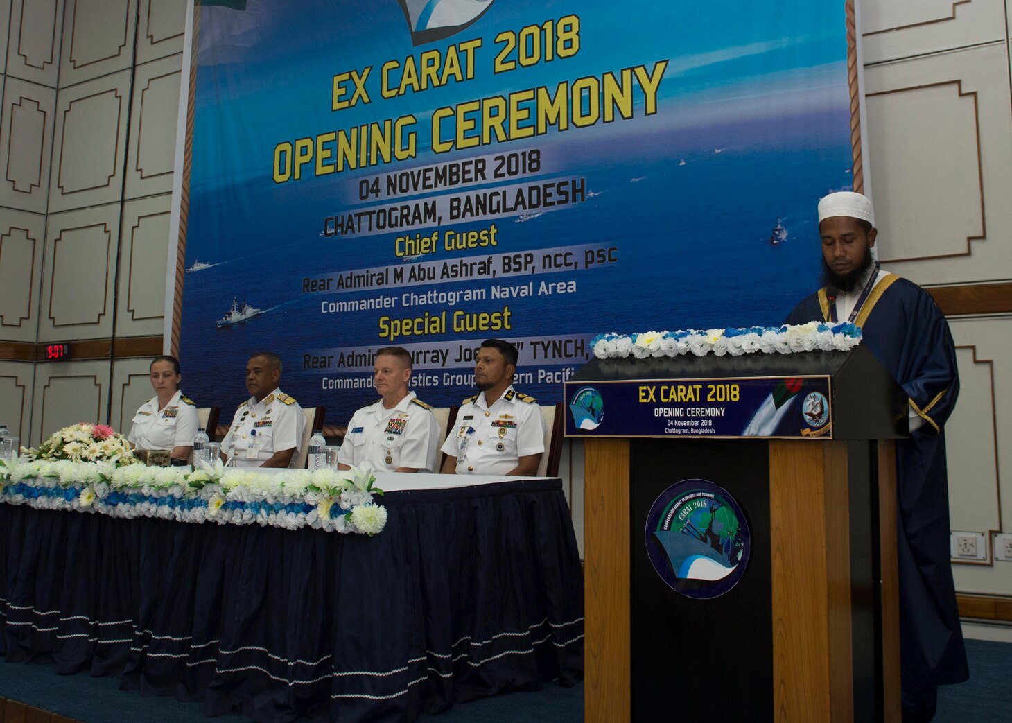 Rear Adm. Joey Tynch, Commander Task Force 73, Capt. Ann McCann, deputy commodore of Destroyer Squadron 7, Rear Adm. M Abu Ashraf, Commander, Chattogram Naval Area, and Rear. Adm. Mohammad Nazmul Hassan, Commander, Bangladesh Navy Fleet listen to a recitation during the opening ceremony Cooperation Afloat Readiness and Training (CARAT) 2018. CARAT Bangladesh 2018 marks the 24th iteration of the maritime exercise series and reflects the strong and mature