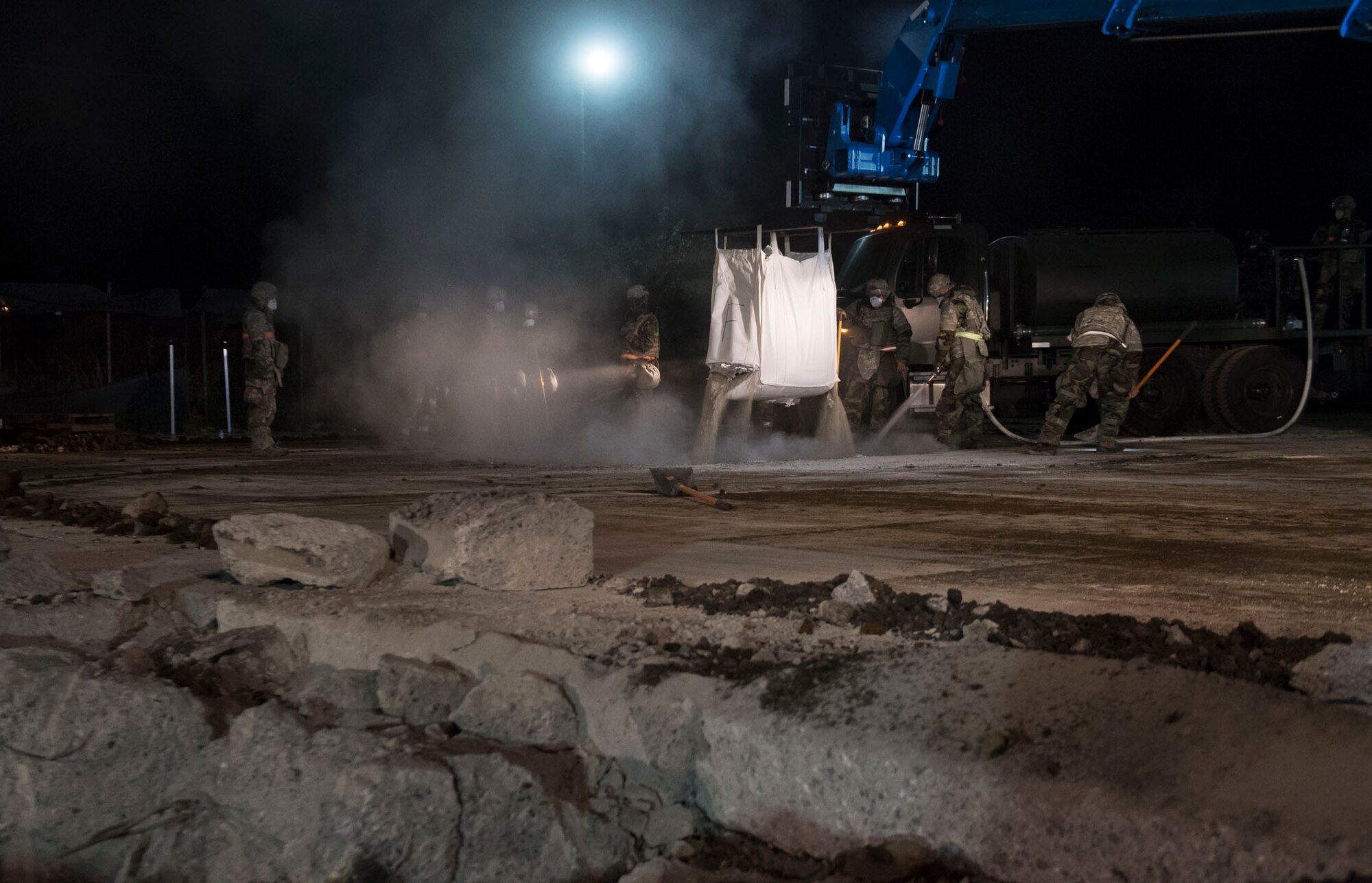 Airmen with the 374th Civil Engineer Squadron fill a crater with water and concrete during Exercise Beverly Morning 18-04, at Yokota Air Base, Japan