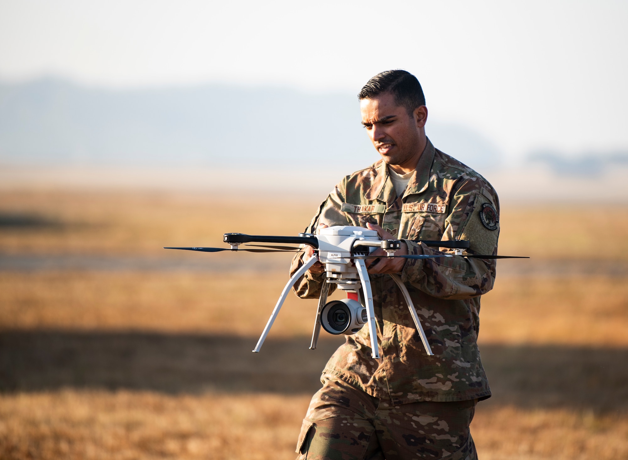 U.S. Air Force Staff Sgt. Nishantkumar Thakar, 8th Civil Engineer Squadron engineering technician, carries a quadcopter at Kunsan Air Base, Republic of Korea, Nov. 2, 2018. The 8th CES is piloting a Rapid Airfield Damage Assessment System program to streamline surveying airfield damage instead of sending personnel into potentially hazardous environments. (U.S. Air Force photo by Senior Airman Stefan Alvarez)