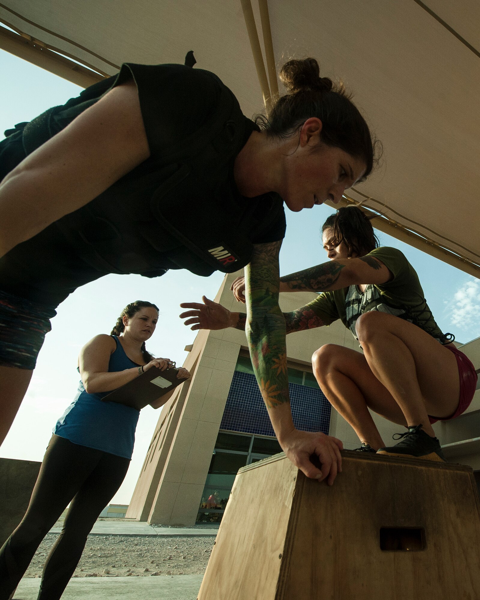 U.S. Air Force Maj. Ashley Parker, 746th Expeditionary Airlift Squadron, rests as her teammate Tech. Sgt. Emily Albonetti, 746th EAS, performs box jumps during the 2018 EOD 133 Memorial Workout Nov. 4, 2018, at Al Udeid Air Base, Qatar. The event was held in honor of U.S. Army Sgt. James Slape, 430th Explosive Ordnance Company, who was killed by an improvised explosive device Oct. 4, 2018. (U.S. Air Force photo by Tech. Sgt. Christopher Hubenthal)