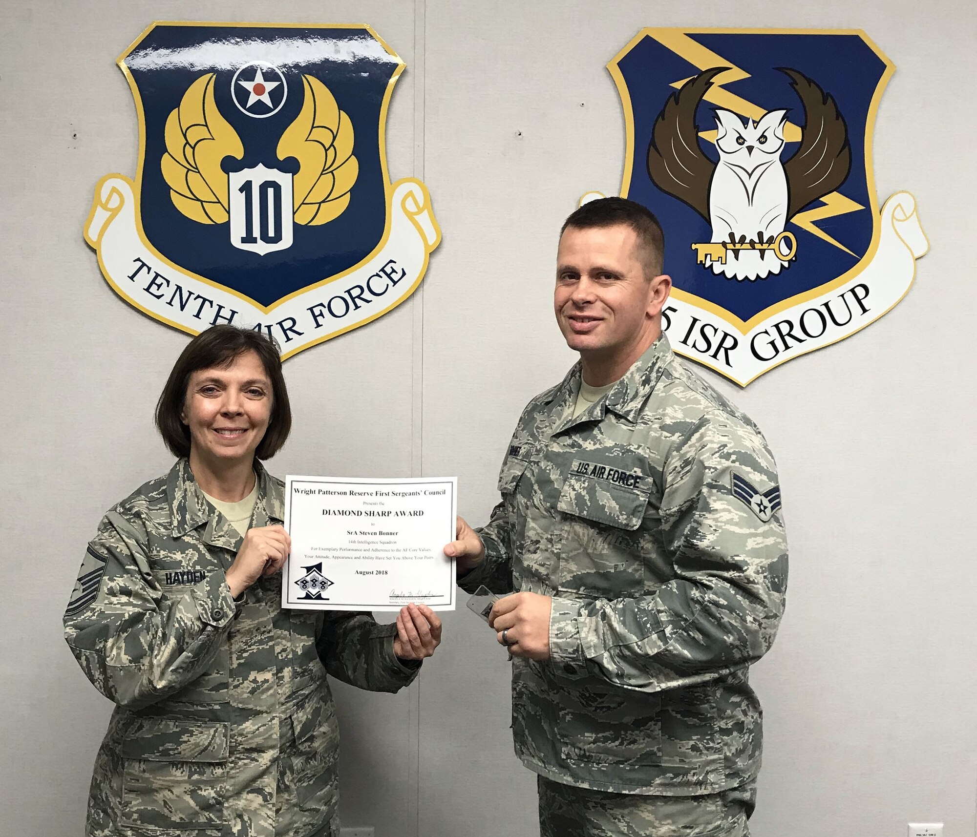 Master Sgt. Angela Hayden, 14th Intelligence Squadron first sergeant, presents the August 2018 Diamond Sharp Award to Senior Airman Steven Bonner, 14th IS, during the October  2018 unit training assembly