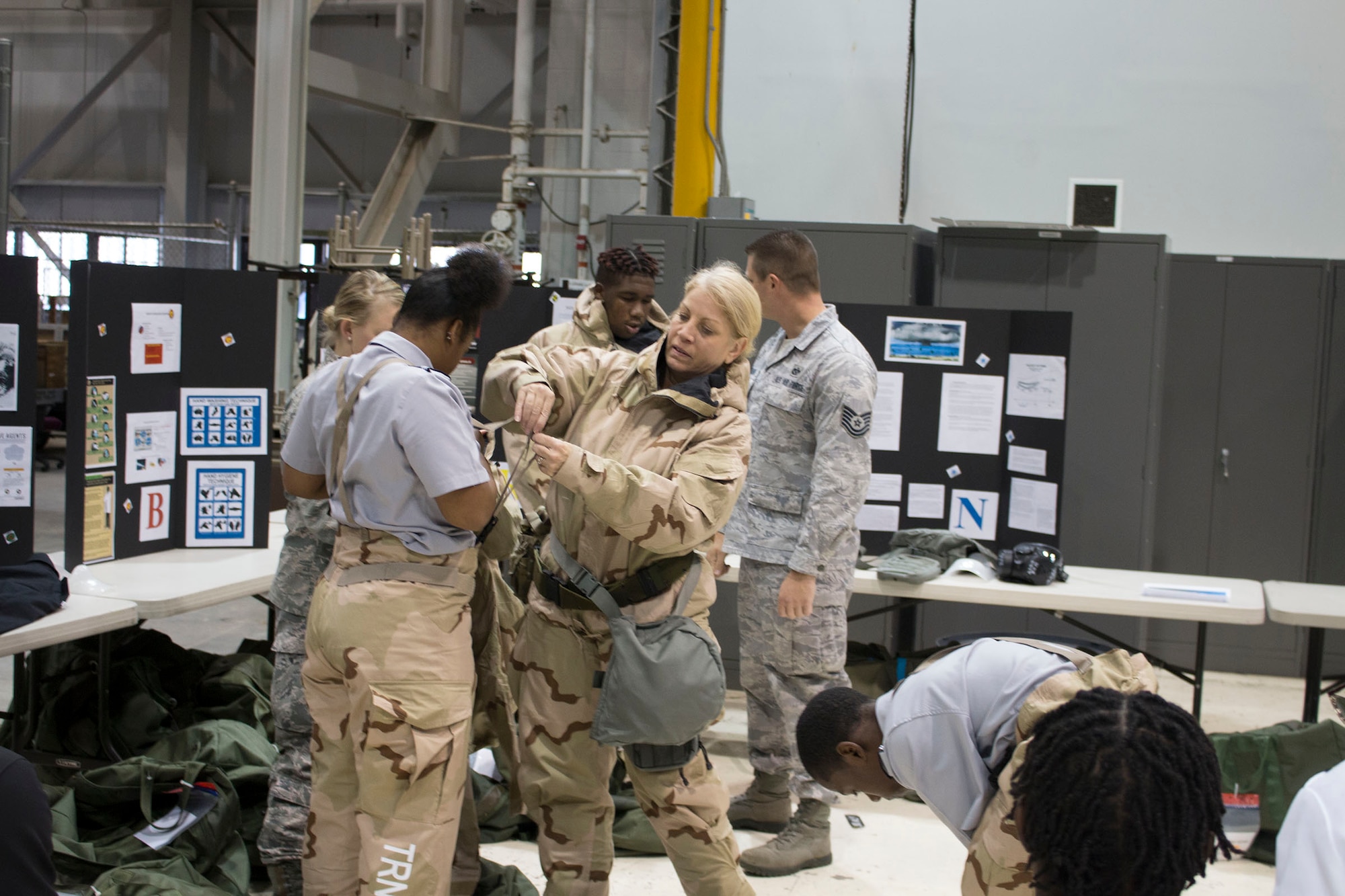 Tech. Sgt. Kathleen Wyatt, 445th Civil Engineer Squadron wing emergency manager, helps a Meadowdale High School student don a chemical warfare suit.