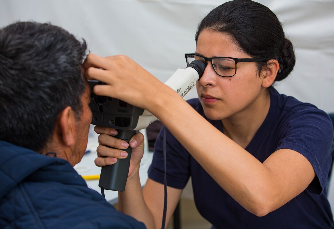 Hospitalman Stacy Rodriguez, from Covina, Calif., performs an eye exam on a patient at one of two medical sites.