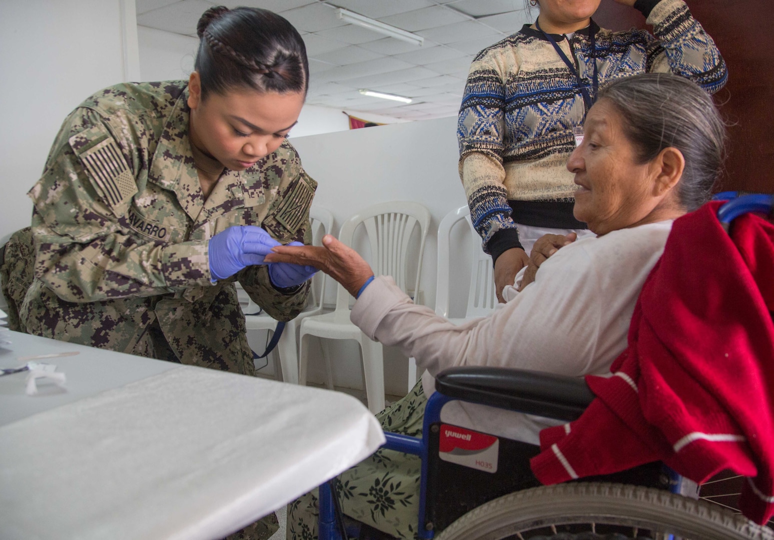 Hospital Corpsman 3rd Class Makhazandra Navarro, from Seattle, draws blood from a patient for laboratory testing at one of two medical sites.
