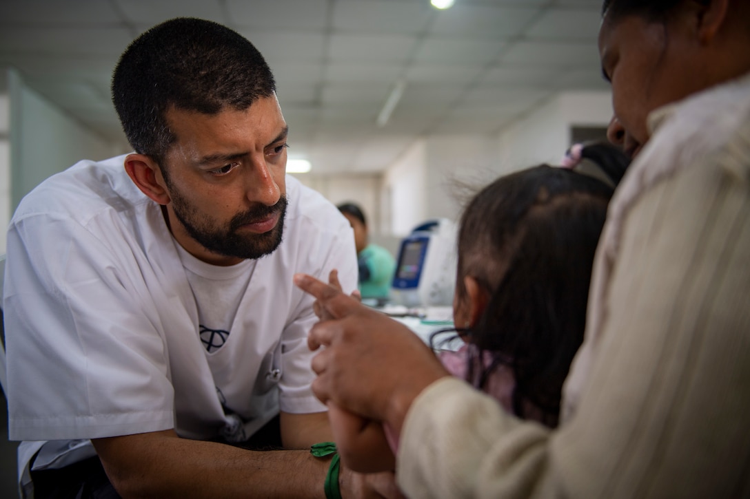 Aldo Buffa, a member of Cascos Blancos of Argentina, prescreens a patient at one of two medical sites.