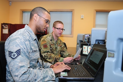 Staff Sgt. Wiggin Bernadotte, a cyber warfare operator in the Washington Air National Guard's 262nd Cyberspace Operations Squadron, works with Capt. Benjamin Kolar, a cyberspace operations officer in the 262nd, on an electrical substation simulator on Nov. 3, 2018. The 262nd is supporting Washington State Secretary of State Kim Wyman to help secure and protect voting systems for the 2018 election.