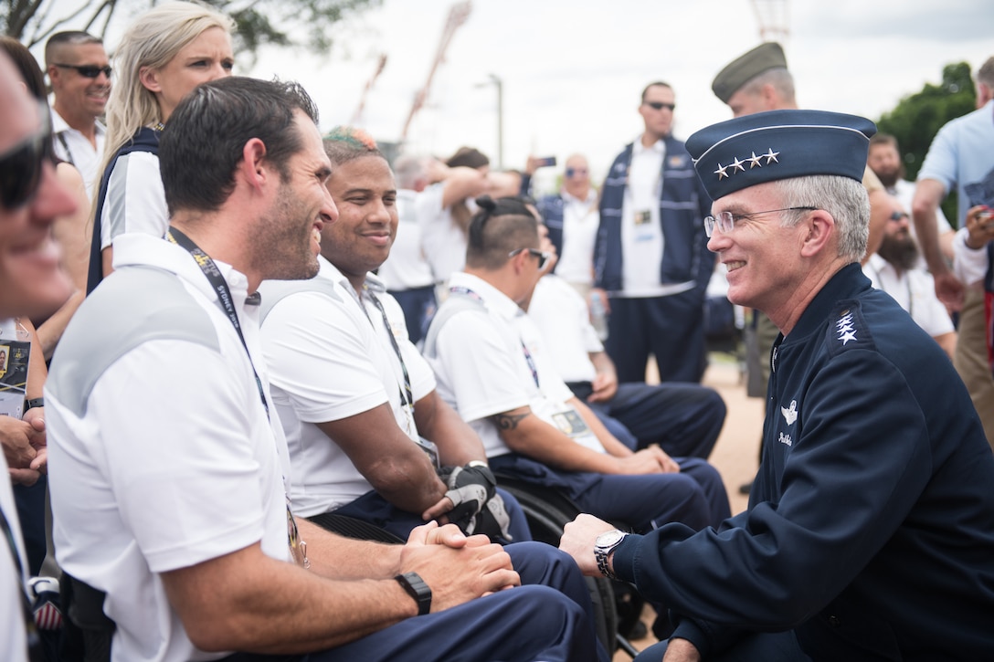 A military officer meets with a group of athletes.