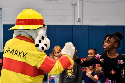 Sparky the Fire Dog high-fives kids Oct. 23, 2018 at the youth center at Joint Base Charleston, S.C. Sparky, along with the children, made a pledge to be drug-free in honor of Red Ribbon Week. As a part of the base’s efforts to take care of service members and their families, drug demand reduction program held several events to educate military youth.