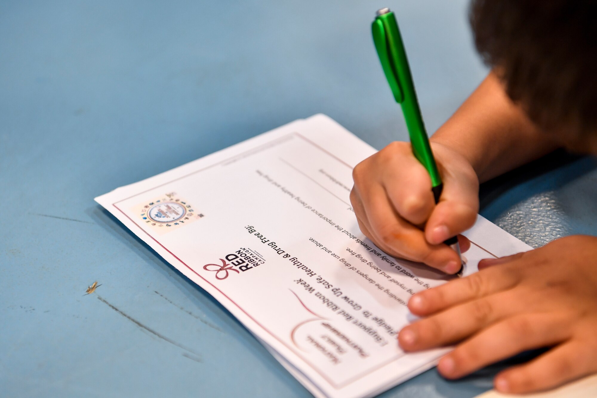 A kid fills out a Red Ribbon Week drug free pledge card Oct. 23, 2018 at the Joint Base Charleston, S.C., youth center.