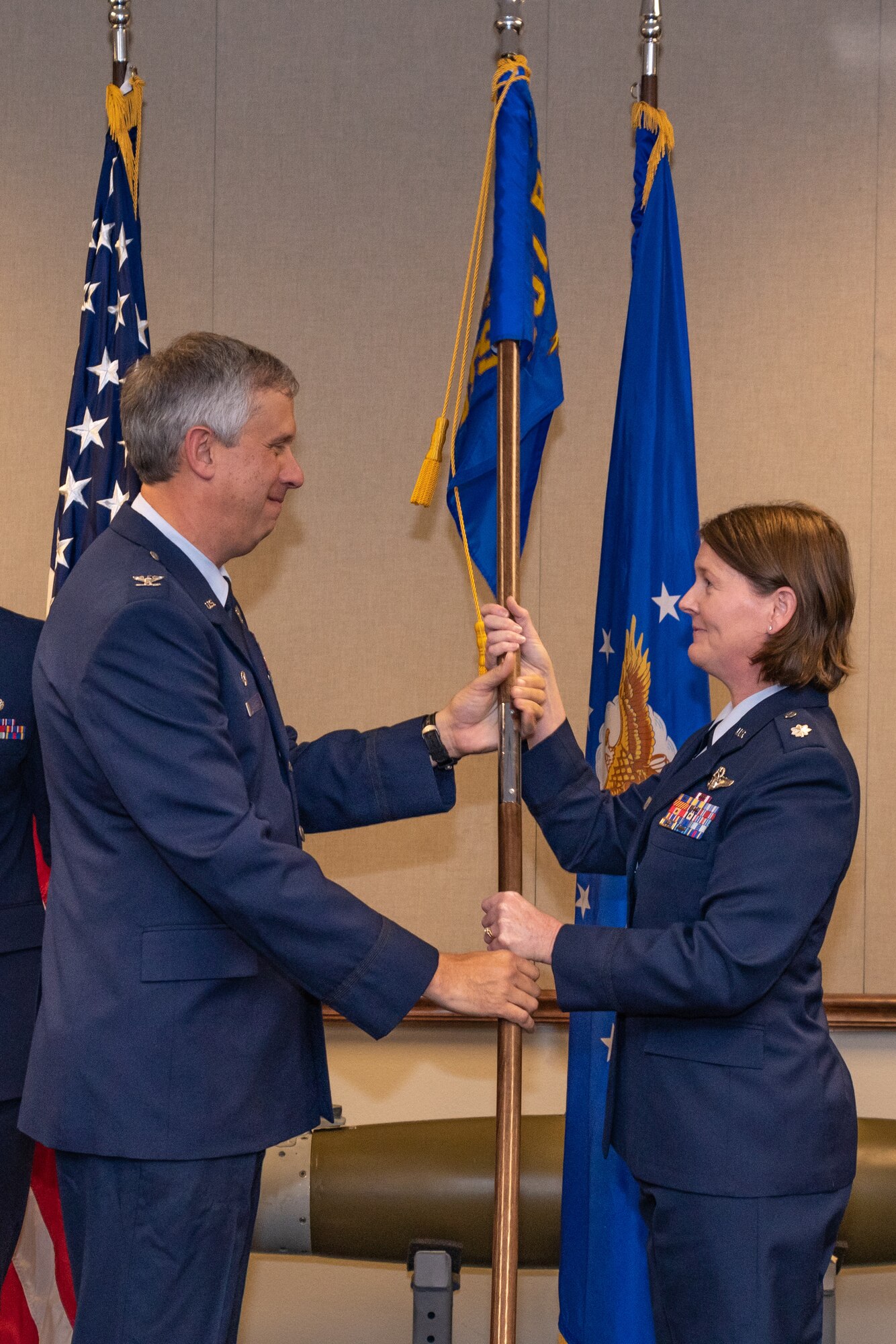 U.S. Air Force Col. Robert Burgess, 307th Operations Group commander, hands the 307th Operations Support Squadron guidon to Lt. Col. Joanna Mitchell during a change of command ceremony at Barksdale Air Force Base, Louisiana, Oct. 3, 2018.  Mitchell took command of the 307th OSS during the ceremony. She has served more than 20 years in the Air Force and has 2,132 flight hours. (U.S. Air force photo by Tech. Sgt. Cody Burt)