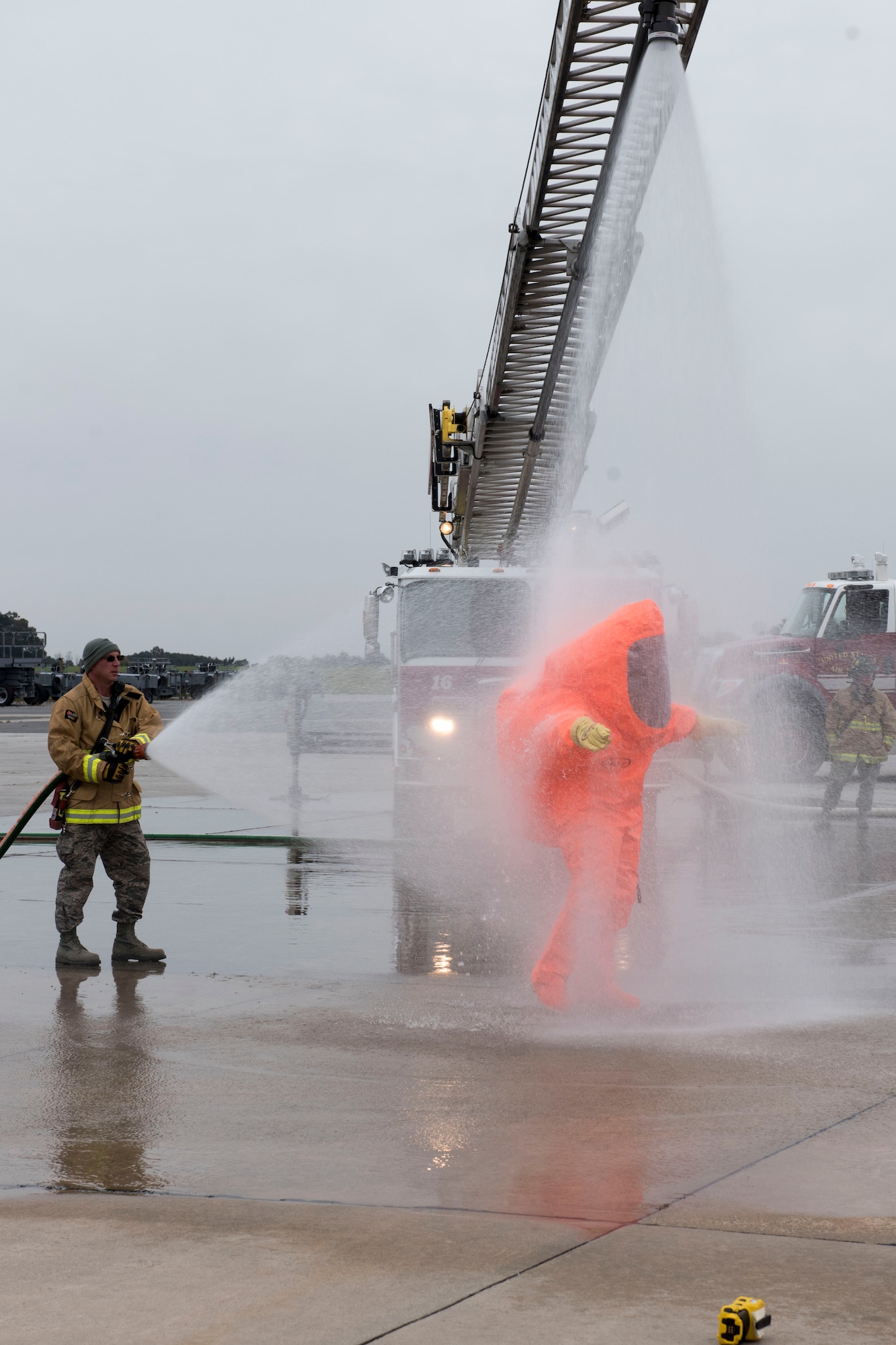 Tech. Sgt. Cheyenne Foltz, assistant chief of fire protection for the 167th Fire Department, sprays Master Sgt. Thomas Mucher with a fire hose to decontaminate his level-A hazmat suit during a hazardous material training exercise at the 167th AW, Oct. 26, 2018. (U.S. photo by Senior Master Sgt. Emily Beightol-Deyerle)