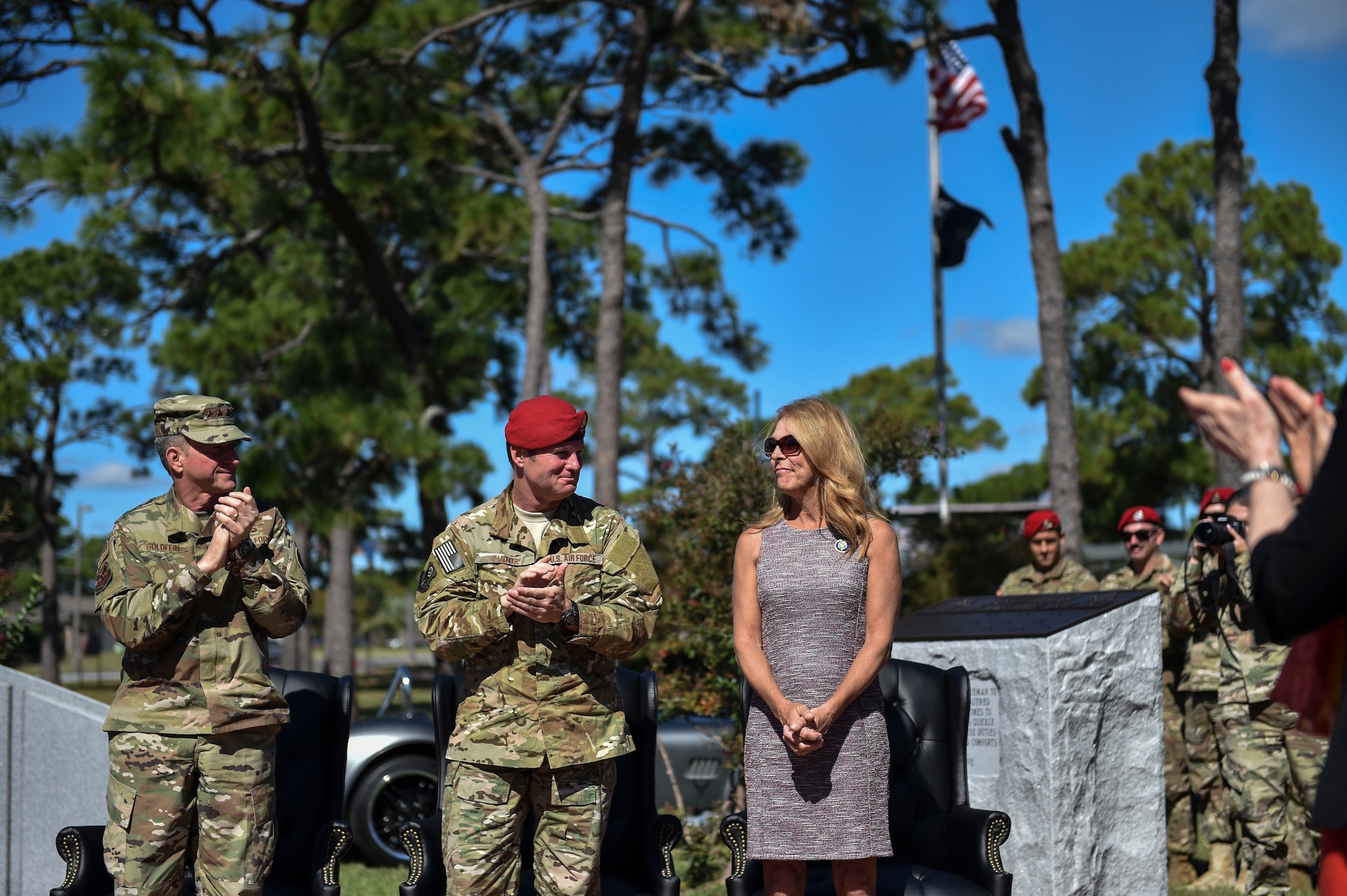 The Chief of Staff of the Air Force, Gen. David Goldfein and U.S. Air Force Col. Claude Tudor, Jr., commander of the 24th Special Operations Wing applaud Valerie Nessel, widow of U.S. Air Force Master Sgt. John Chapman, during a Medal of Honor memorial unveiling ceremony on Oct. 27, 2018, at Hurlburt Field, Florida.