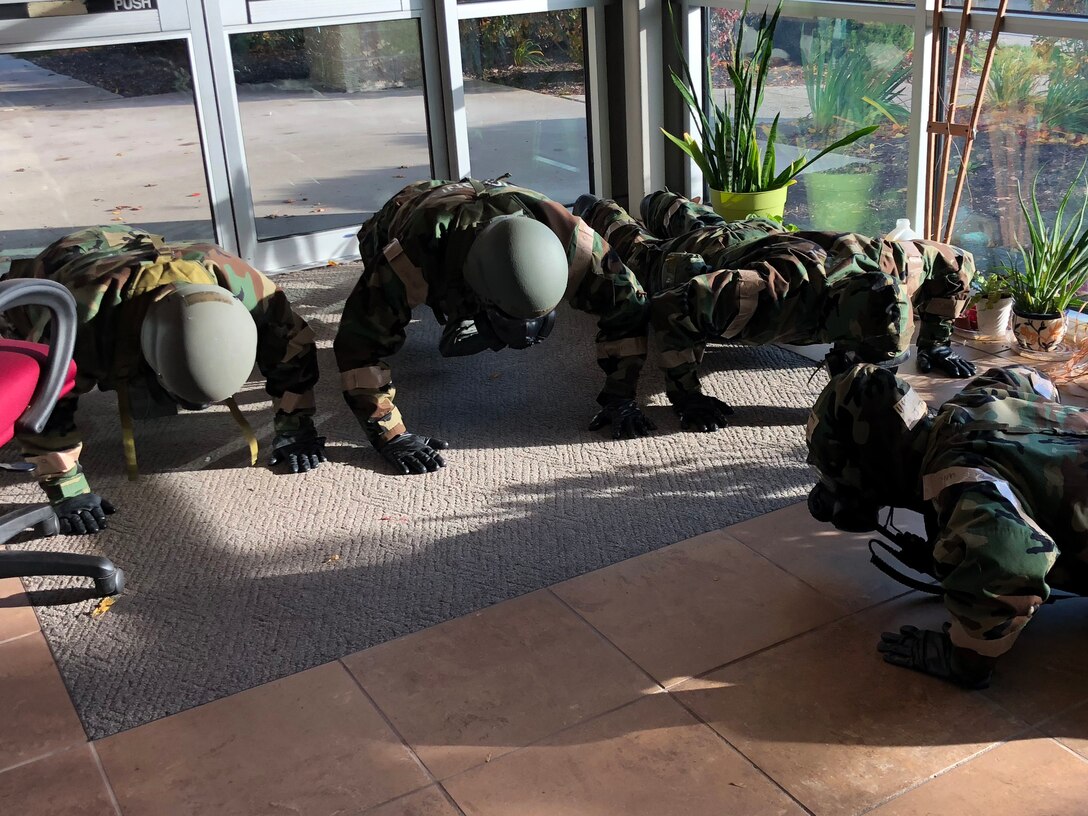 Airmen from the 104th Fighter Wing work in Mission Oriented Protective Posture level four Nov. 4, 2018, at Barnes Air National Guard Base, Massachusetts. The airmen kept morale high while working to enhance mission readiness.  (U.S. National Guard photo by 2Lt. Amelia Leonard. Cleared for public release)